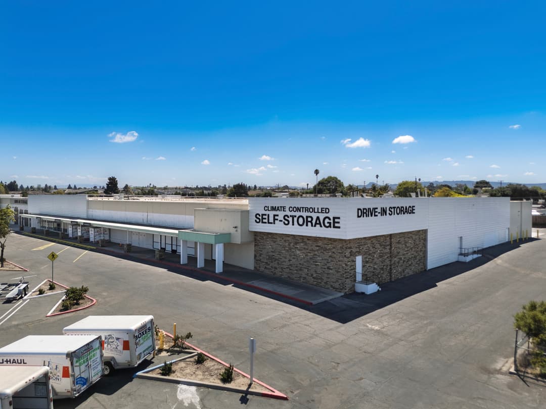 Climate-controlled self-storage facility with a drive-in entrance and ample parking space.