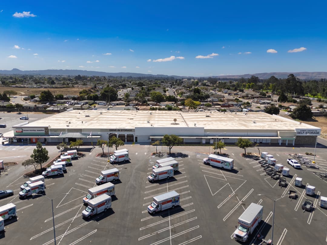 Aerial view of a self-storage facility with moving trucks in the parking area.