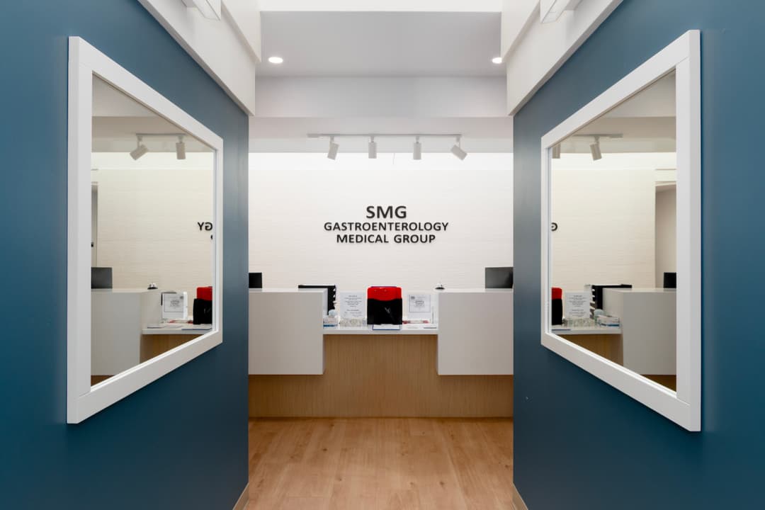 Modern gastroenterology clinic reception area with mirrored walls and sleek design.
