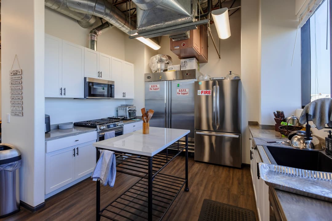 Modern kitchen with stainless steel appliances, white cabinets, and a central island.