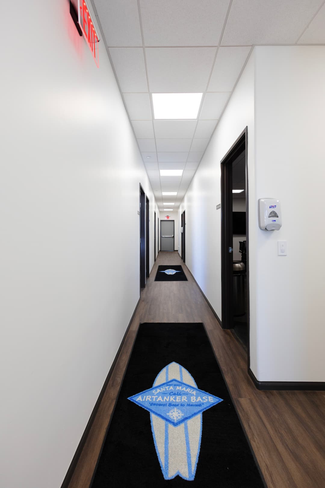 Hallway at air tanker base featuring logo mats and modern design elements.