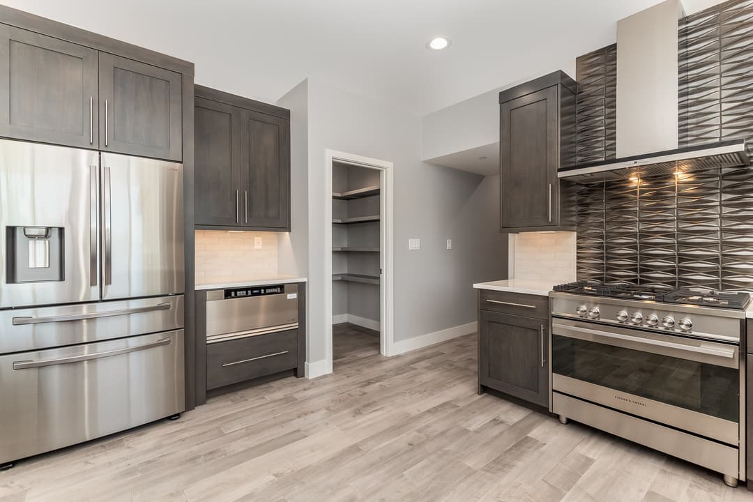 Modern kitchen with stainless steel appliances, sleek cabinetry, and stylish tile backsplash.