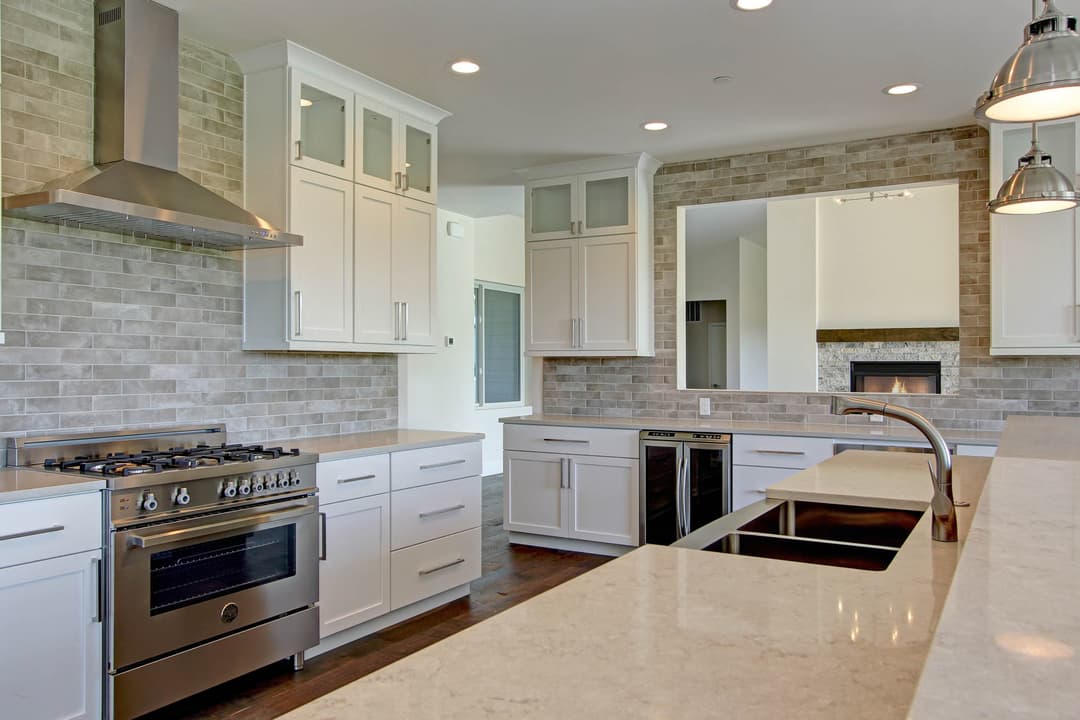 Modern kitchen with stainless steel appliances, granite countertops, and white cabinetry.