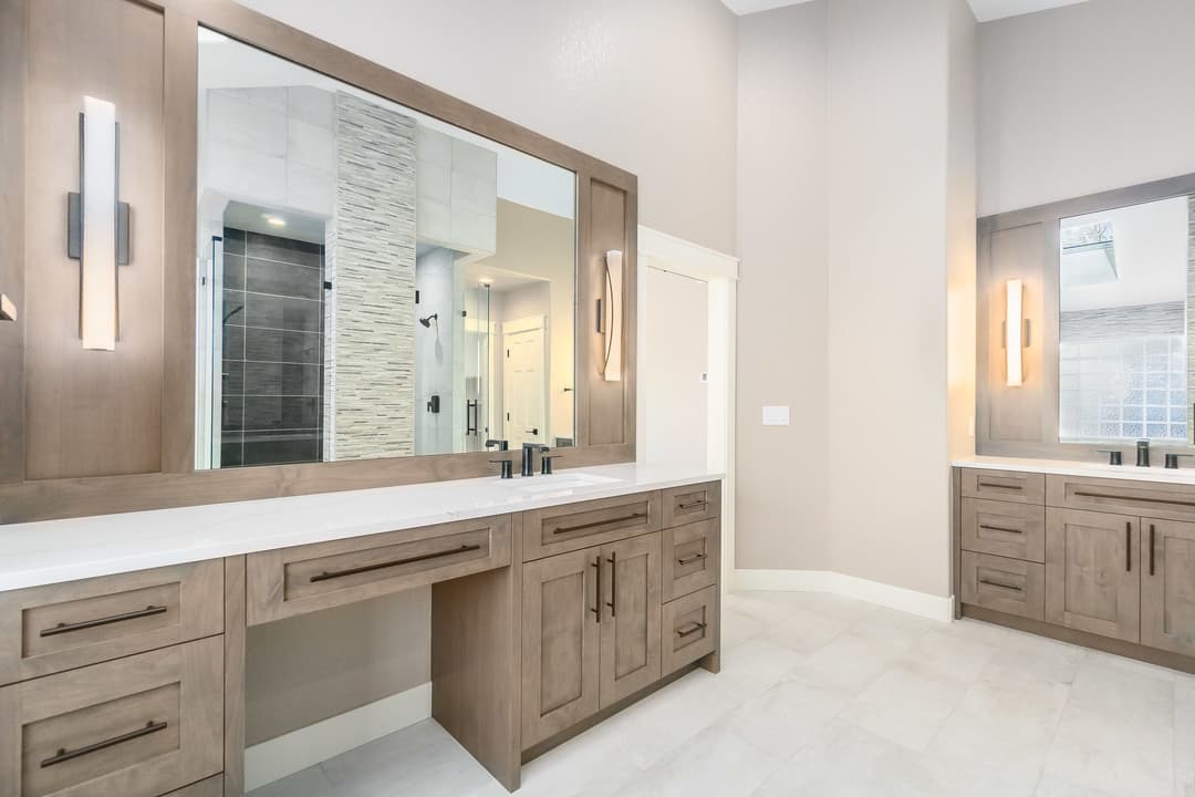 Modern bathroom with double vanities, large mirrors, and stylish lighting fixtures.