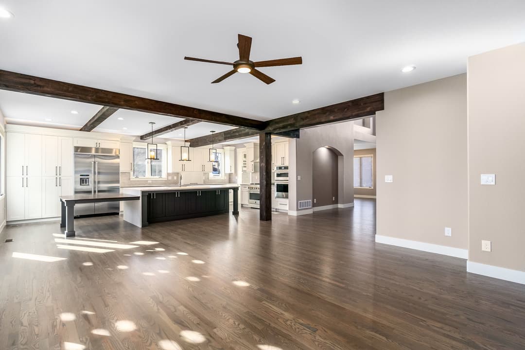 Spacious modern kitchen with wooden beams, stainless appliances, and open floor layout.