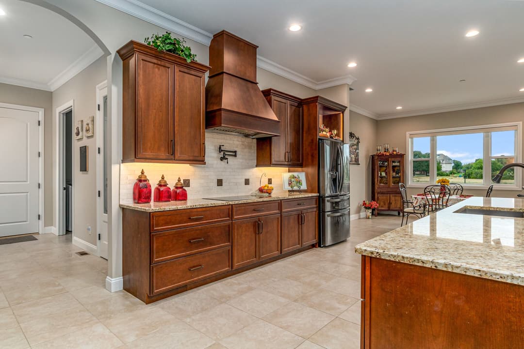 Modern kitchen with wood cabinetry, granite countertops, and stainless steel appliances.