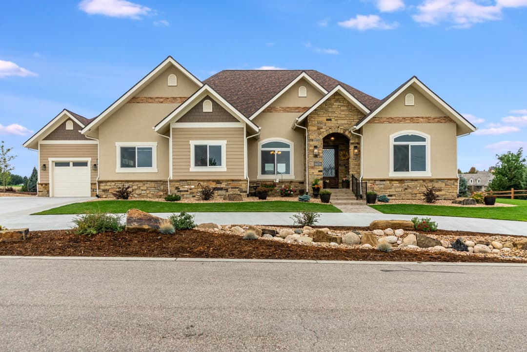 Modern ranch-style home with stone accents and landscaped front yard. Ideal family residence.