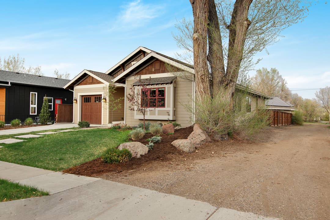 Charming house with landscaped yard and gravel driveway in a peaceful neighborhood.