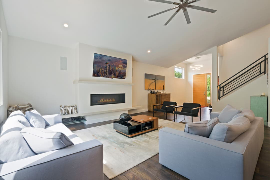 Modern living room with a fireplace, stylish furniture, and large windows for natural light.