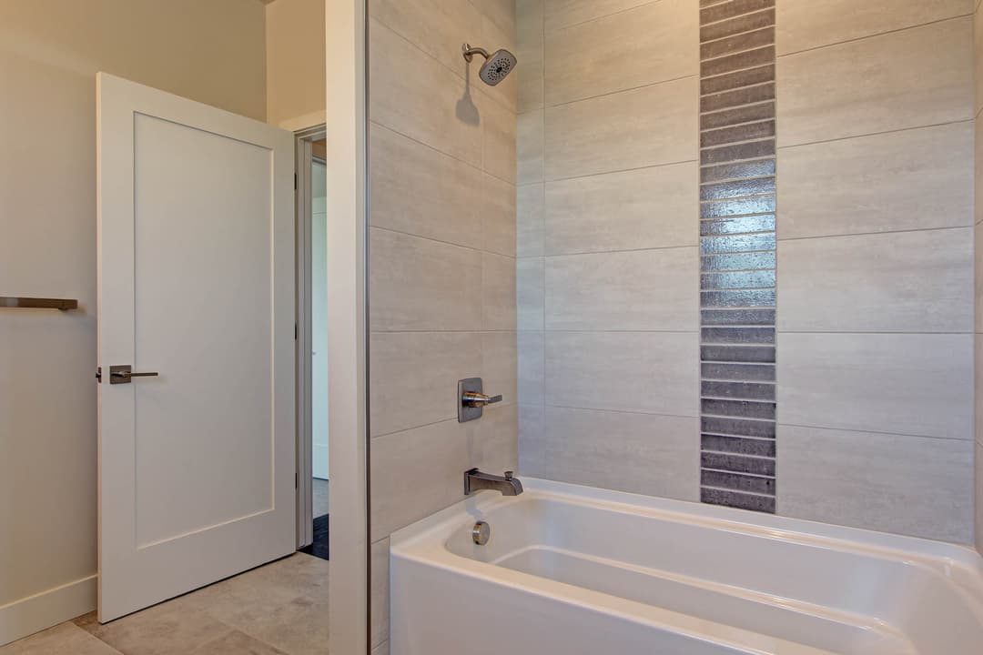 Modern bathroom featuring a sleek bathtub, stylish shower, and contemporary tile design.
