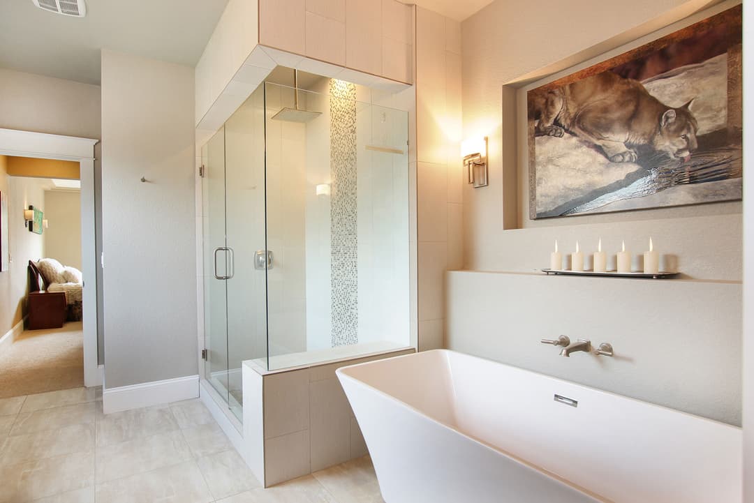 Modern bathroom with a glass shower, freestanding tub, and stylish wall art.