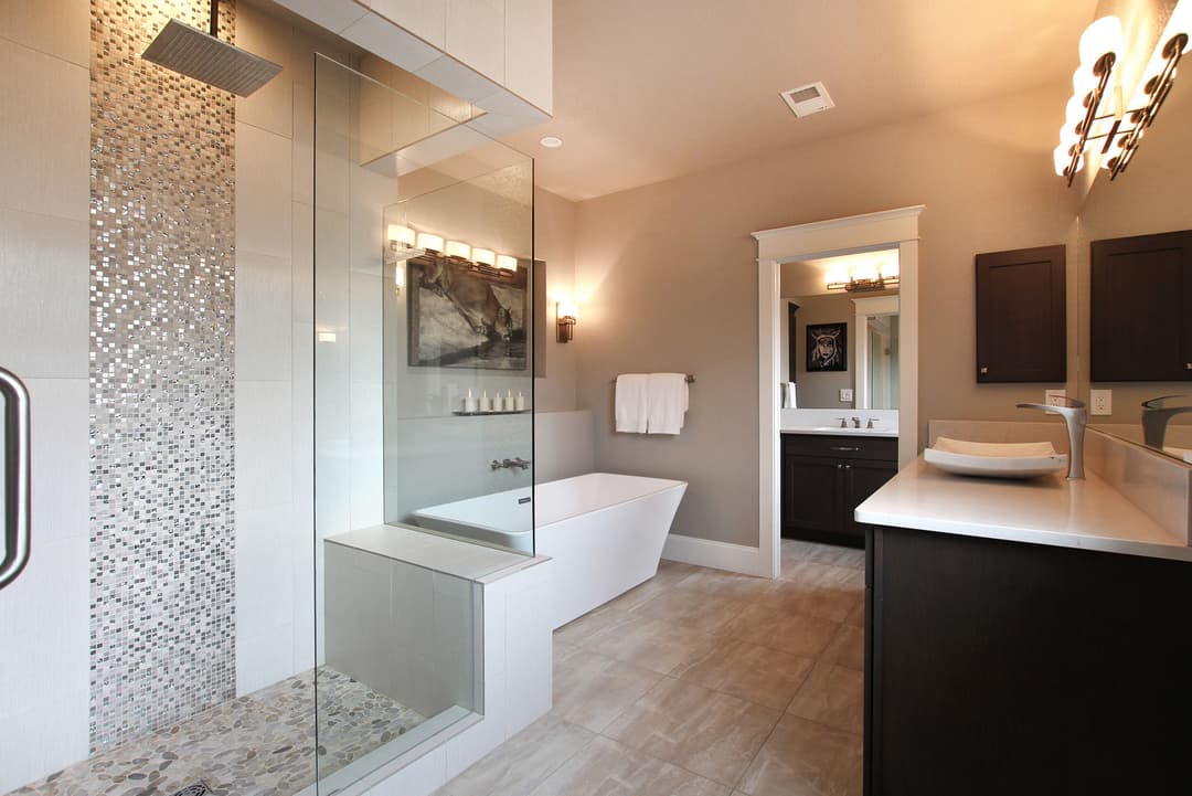 Modern bathroom featuring a walk-in shower, freestanding tub, and elegant lighting.