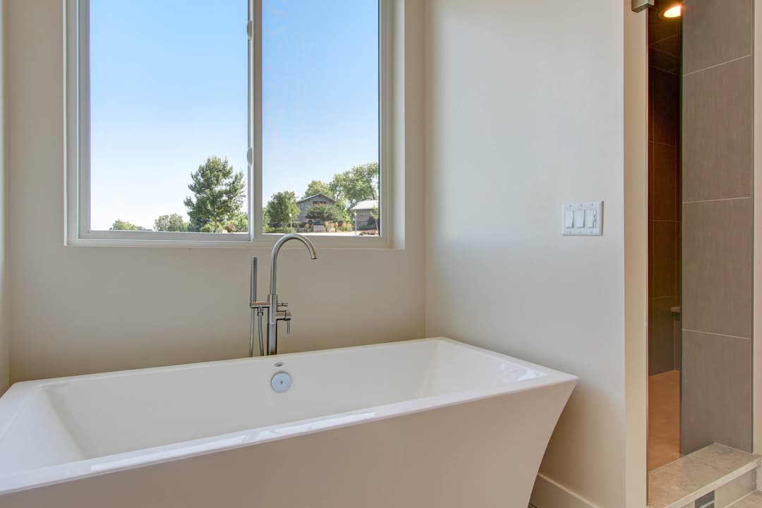 Modern bathroom featuring a freestanding bathtub and a walk-in shower with natural light.