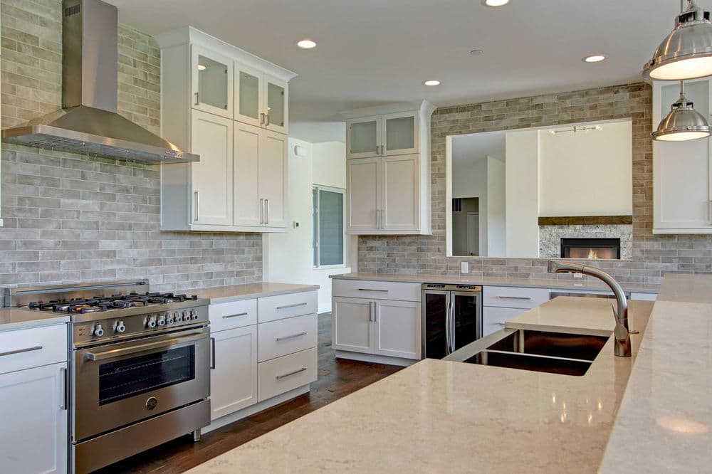 Modern kitchen with white cabinets, stainless steel appliances, and a quartz countertop.