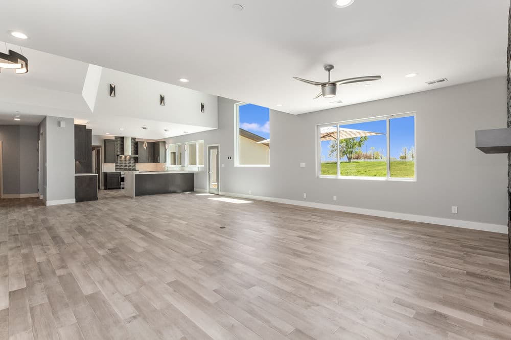 Spacious modern living room with large windows and sleek finishes, featuring open layout.